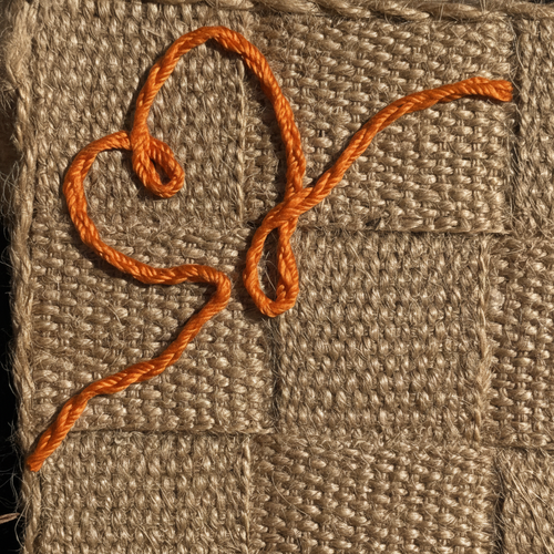 Embraceriet signaturlinje i Rognebær-oransje på håndflettet jute